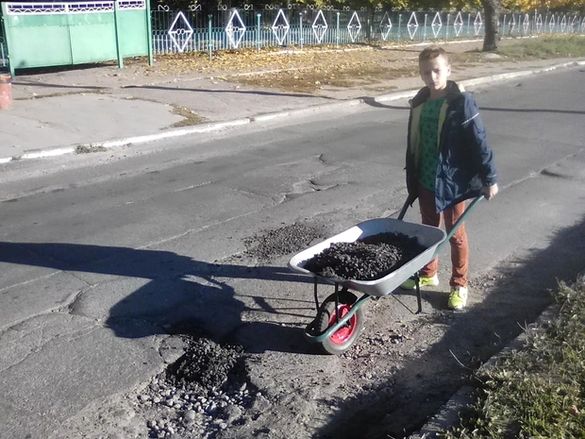 У Черкасах чоловік із сином власними силами ремонтують розбиту вулицю (ФОТО)